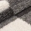 A close-up view of a shaggy rug with a checkered pattern in gray and white. Náhľad obrázku produktu