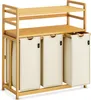 A three-compartment laundry hamper with two shelves, made of bamboo and beige fabric. Anteprima dell’immagine prodotto