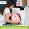 A woman is putting a pink fabric into a washing machine. Produktbild-Vorschau