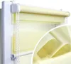 A close-up view of a cream-colored roller blind with a dual-layer design, showing both opaque and sheer stripes. The blind is installed on a white window frame and features a pull cord. A magnified inset shows the texture of the fabric.