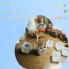 A collection of resin cubes with embedded natural elements, along with empty resin molds, arranged on a wooden surface. Voir les images du produit