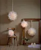 Several paper star lanterns are displayed in a room, with one placed on a chair and others hanging. Podgląd zdjęcia produktu