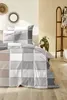 A bedroom scene with a bed made with a checkered duvet cover. Produktbild-Vorschau