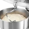 A close-up view of a stand mixer's dough hook mixing dough in a stainless steel bowl. Produktbild-Vorschau