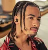 A close-up shot of a young man wearing wireless earbuds, with a vintage record player in the background. Produktbild-Vorschau