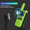 A green walkie-talkie and a black Bluetooth headset are shown against a dark background, with a graphic indicating Bluetooth connectivity. Voir les images du produit