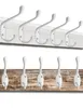 Two rows of white coat hooks mounted on wooden boards. Produktbild-Vorschau