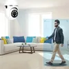 A man walks through a living room with a security camera mounted on the ceiling. Anteprima dell’immagine prodotto