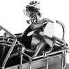 A close-up view of a metal figurine of a tractor with a driver and a dog, made from nuts, bolts, and other metal parts. Anteprima dell’immagine prodotto