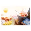 A breakfast setting with bacon, eggs, orange juice, and a bowl of oatmeal with strawberries, placed on top of books. Produktbild-Vorschau