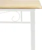 A close-up view of the edge of a wooden tabletop and the white metal frame of a table. Náhled obrázku produktu