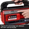 A close-up of a red and black Einhell battery-powered compressor with a digital display, being operated by a person's hand. Produktbild-Vorschau