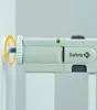 Close-up of a safety gate mechanism, showing a screw being tightened into a wall mount. Voir les images du produit