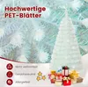 A white artificial Christmas tree with gifts at its base, set against a blurred background of similar trees and decorations. Text overlays highlight product features. Produktbild-Vorschau