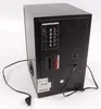 The back panel of a black subwoofer speaker with various input/output connections and a power cord. Produktbild-Vorschau
