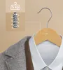 A close-up of a gray jacket and a white shirt on a wooden hanger, with a graphic overlay indicating a 5kg weight capacity. Náhled obrázku produktu