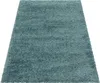 A close-up, angled view of a blue shaggy rug on a white background.