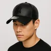 A close-up portrait of a man wearing a black New York Yankees baseball cap. Náhľad obrázku produktu
