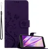 A purple phone case with a floral and butterfly design is shown open, with a smartphone inside. A wrist strap is attached to the case. Náhled obrázku produktu