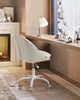 A white office chair is placed next to a wooden desk by a large window, with a fireplace visible on the left. Produktbild-Vorschau