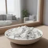 Weiße Deko-Steine in einer hellen Schale auf einem Fenstersims im Innenraum Produktbild-Vorschau