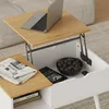 A lift-top coffee table with a laptop, newspaper, and bowl of chocolates on it, shown in an open state to reveal storage. Voir les images du produit