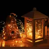 A wooden lantern and birdhouse decorated with string lights against a dark background. Produktbild-Vorschau