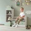 A young boy sits on a children's storage bench with a house-shaped shelf unit next to him, in a room with light green walls. Podgląd zdjęcia produktu