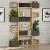 A modern bookshelf filled with books, plants, and decorative items, set against a white brick wall. Náhled obrázku produktu