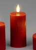 Three red LED candles with a ribbed texture and a flickering flame on a plain gray background. Produktbild-Vorschau