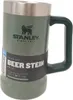 A green Stanley beer stein with a silver lid and black handle, set against a white background. Voir les images du produit