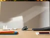 A desk with a trackball mouse, keyboard, cup, and books. Anteprima dell’immagine prodotto