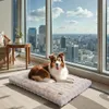 A dog lying on a dog bed in front of a large window with a city view. Anteprima dell’immagine prodotto