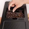 A hand is adjusting a dial on a coffee grinder filled with coffee beans. Produktbild-Vorschau