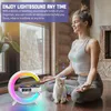 A woman is meditating with a cat next to a crescent-shaped LED lamp with a clock and wireless charger. Produktbild-Vorschau