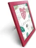 A red picture frame with a tropical leaf pattern inside, standing on a white surface. Produktbild-Vorschau
