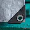 Close-up of a reinforced corner with a grommet on a silver tarp. Produktbild-Vorschau