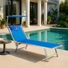 A blue sun lounger is placed next to a swimming pool on a tiled patio. Produktbild-Vorschau
