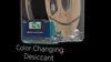 A close-up of a desiccant device with a digital display showing 10% humidity, placed next to a spool of 3D printer filament. Text overlay reads 'Color Changing Desiccant'. Podgląd zdjęcia produktu