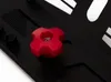 A close-up of a red knob on a black surface, with some white markings in the background. Anteprima dell’immagine prodotto