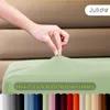 A hand is shown stretching a light green fitted sheet over a mattress. Below the sheet, a row of different colored fabric swatches is displayed. Produktbild-Vorschau