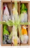 A set of six decorative gnomes in a cardboard box, tied with a green ribbon. Produktbild-Vorschau