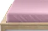 A close-up view of a pink fitted sheet on a wooden bed frame. Náhled obrázku produktu