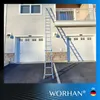 A ladder is leaning against a house with two garage doors. Produktbild-Vorschau