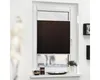 A brown pleated blind is installed on a white window frame, covering the lower part of the window. The blind is partially lowered, showing the pleats. The windowsill below has a few decorative items and a potted plant. Produktbild-Vorschau
