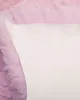A close-up view of a pink sheepskin rug with a white backing. Produktbild-Vorschau