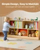 A young child is interacting with a wooden bookshelf filled with books and toys in a child's room. Anteprima dell’immagine prodotto
