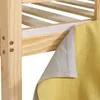Close-up of a wooden bed frame with a yellow fabric curtain attached via velcro. Produktbild-Vorschau