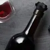 A close-up shot of a wine bottle with a vacuum pump stopper and a glass of red wine. Náhled obrázku produktu