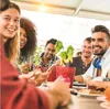 A group of friends laughing and enjoying a meal together at an outdoor restaurant. Podgląd zdjęcia produktu